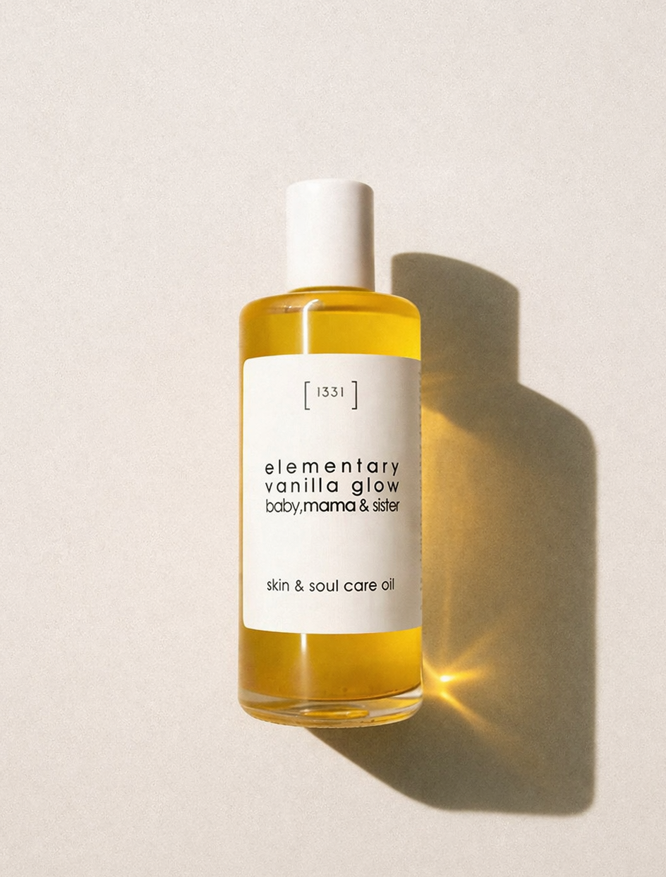 Bottle of 'elementary vanilla glow' skincare oil on a beige background